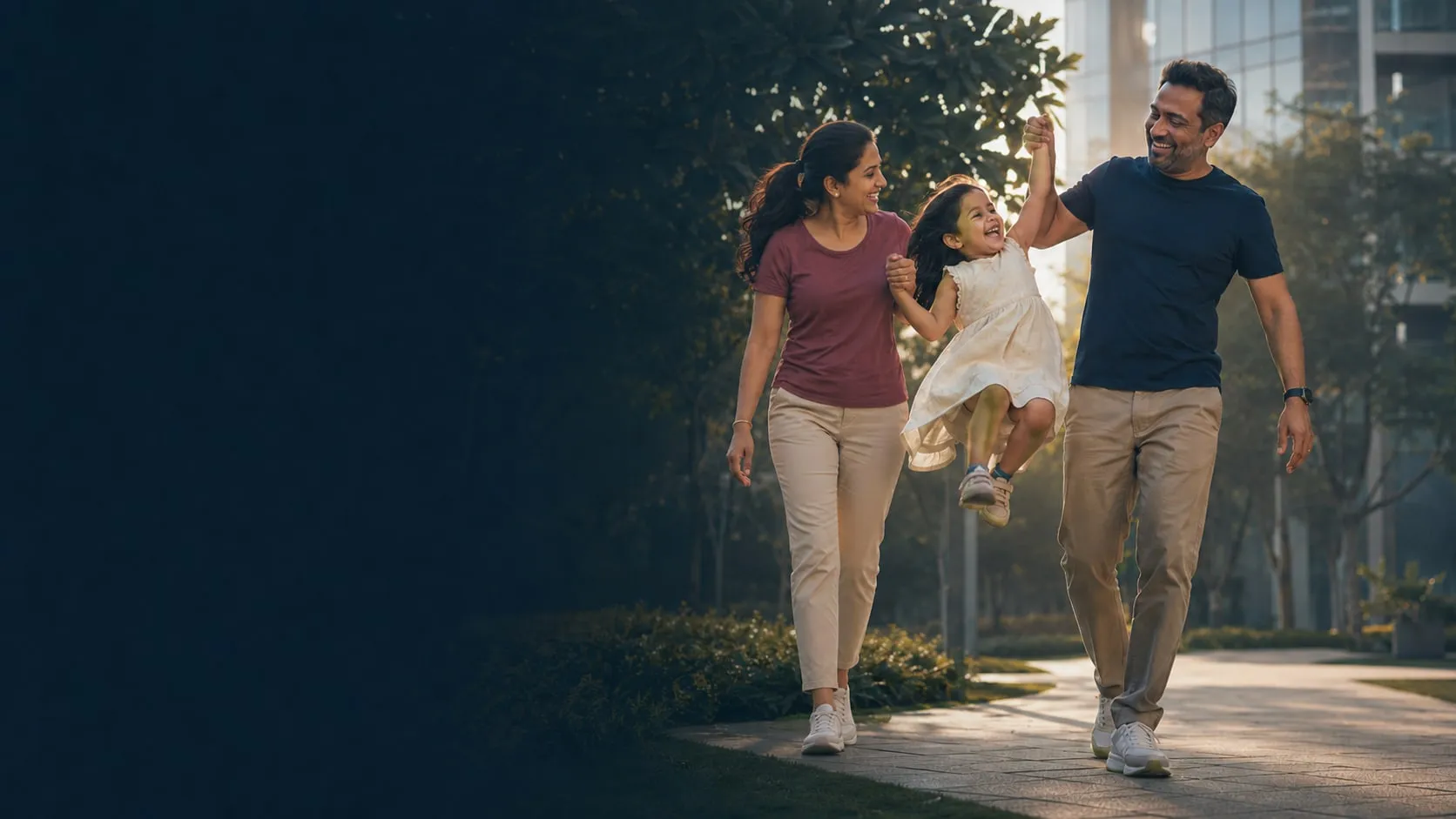 A mother and father swing their laughing daughter between them on an evening walk